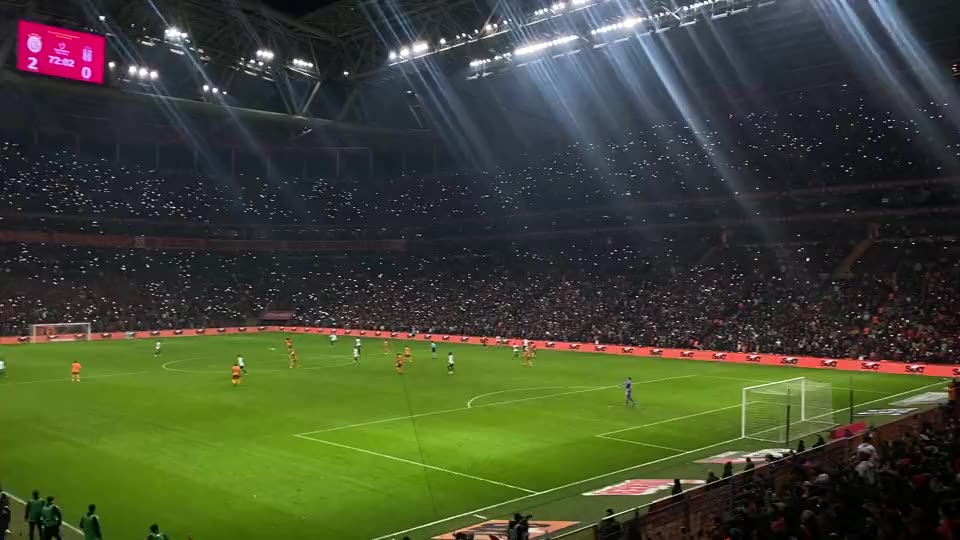 Packed football stadium during a night match